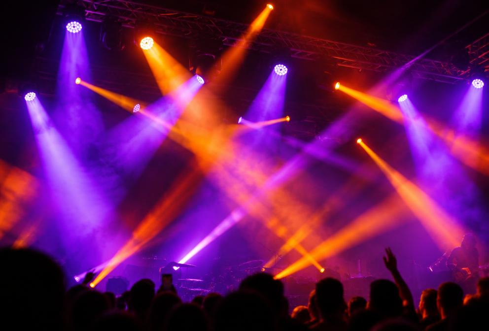 Moving head lighting fixtures on truss above a stage